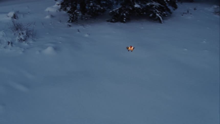 A drone flies fast over the snow