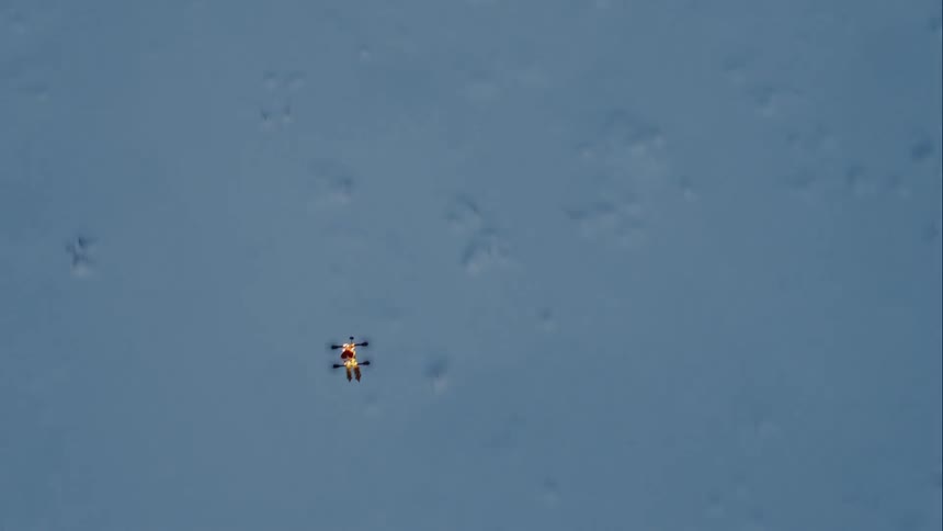 A drone flies over a snowy landscape