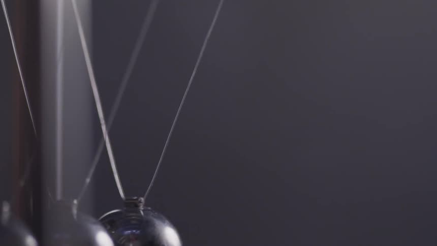 Balls crash together as pieces swing on a newtons cradle