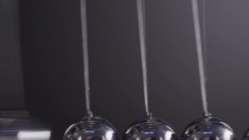 Close up of pendulum balls swinging back and forth