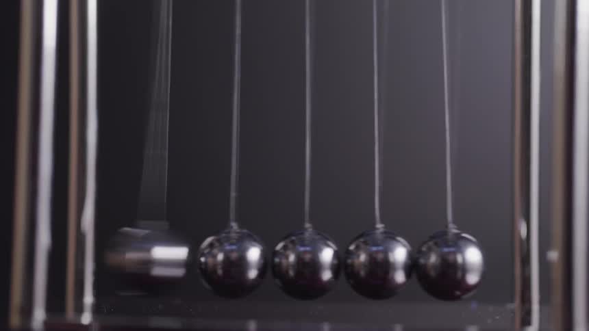 Silver balls on a pendulum hit one another and move back and forth