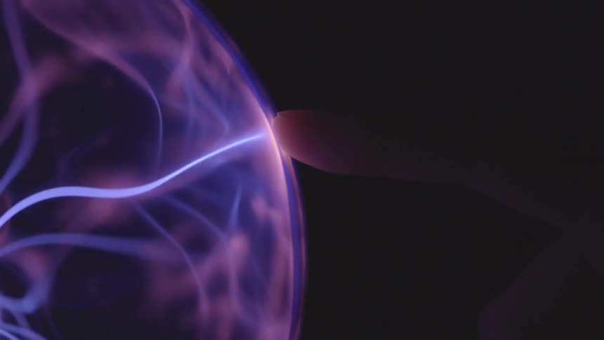 A person puts their finger on a plasma ball