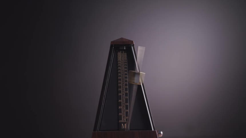 Close up of old vintage metronome in swinging