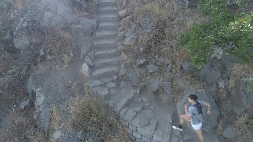 An aerial view of a person running on stone stair