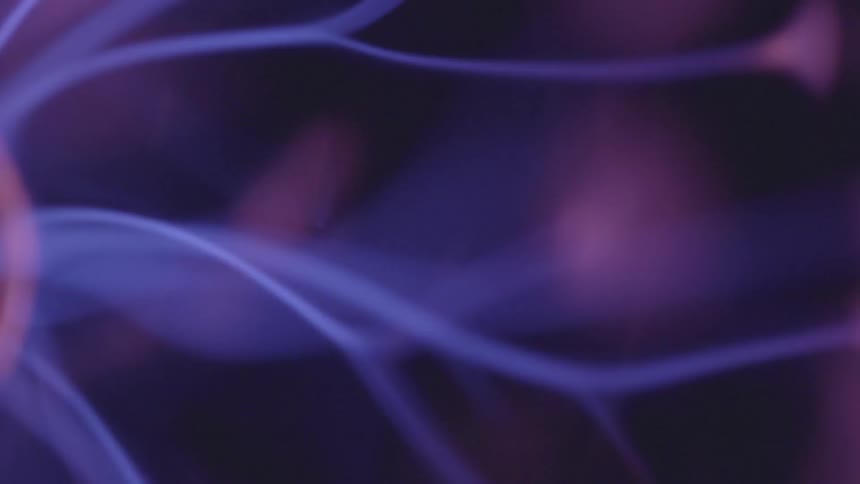 The blue filaments of a plasma globe glow and dance