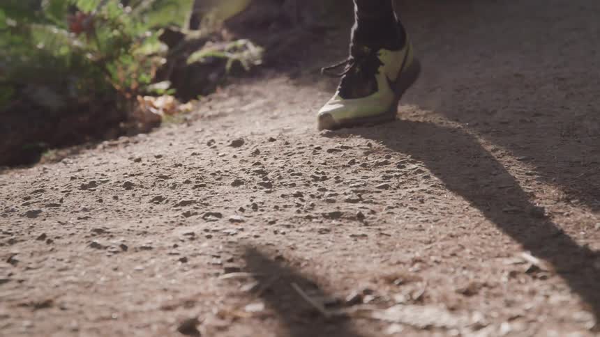 Man runs on dirt road on a sunny day