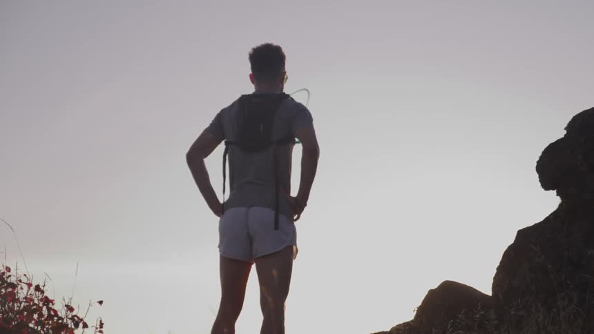 A portrait of a man standing near the cliff