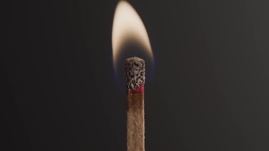 A match burning against a dark backdrop