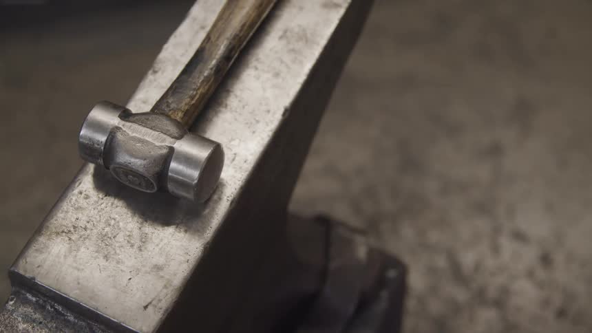 Silver hammer lays on the anvil