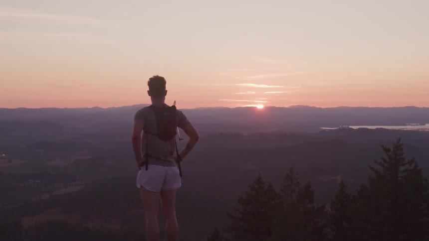 Man looks at the mountains then turns to jog away