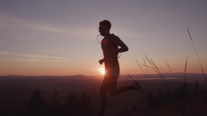 A silhouette of a man running at dawn