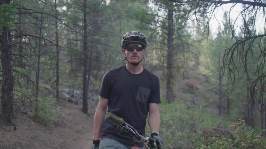 Mountain biker in the woods staring into distance