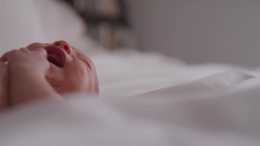 A baby is laying in the bed