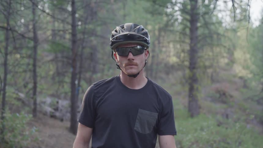 A portrait of a man with a bike helmet and glasses