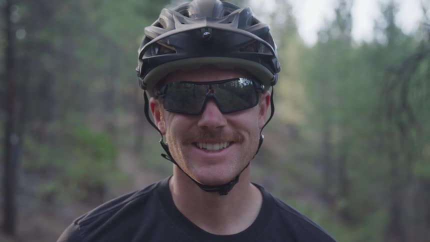 A man with a helmet and shades smiling