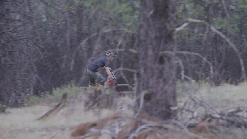 Man rides a bike on the forest track in the woods