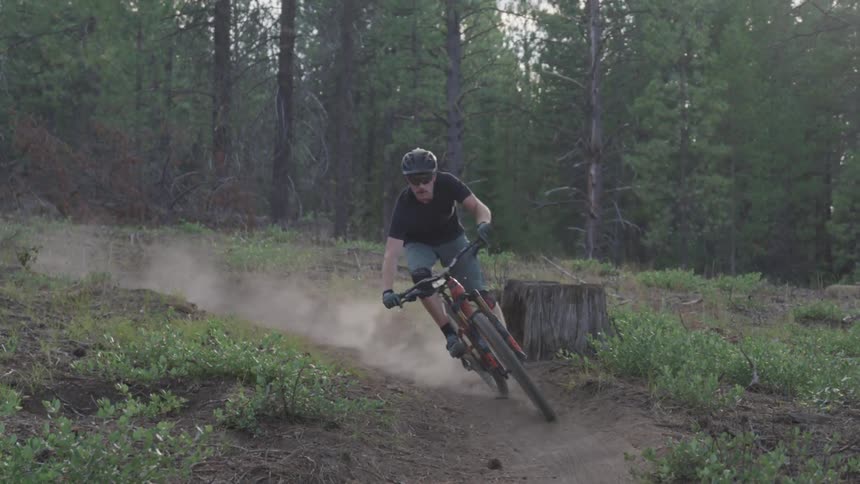 Man rides a bike on the forest track in the woods