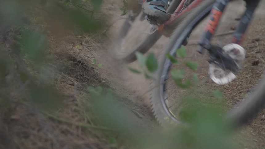 Man rides a bike on the winding forest road in the woods