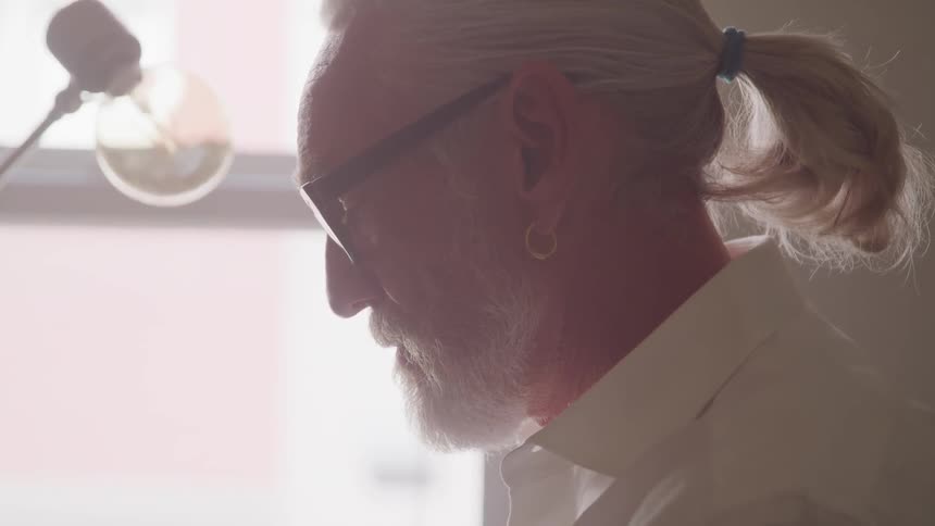 A man is looking at a light bulb indoors