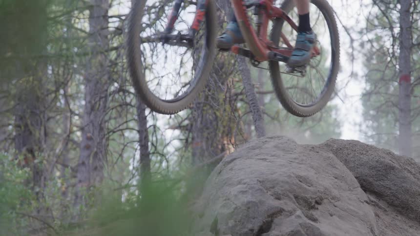 A biker jumps over the rock cliff