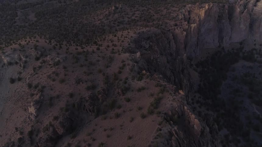 Passing over brush covered rock formations cliffs and ridges