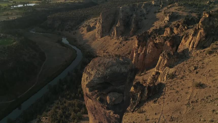 A hoodoo near a river in the valley of a badland