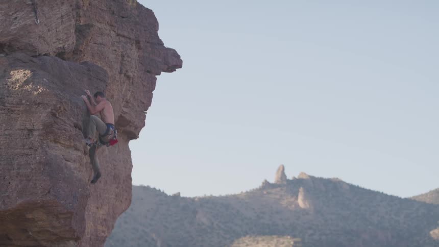 Man climbing steep mountain cliff