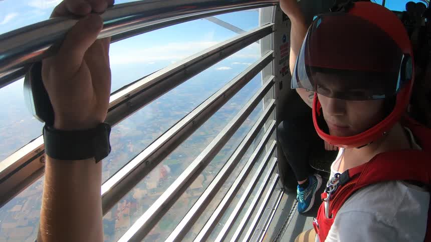 People hold on to safety bars in a helicopter