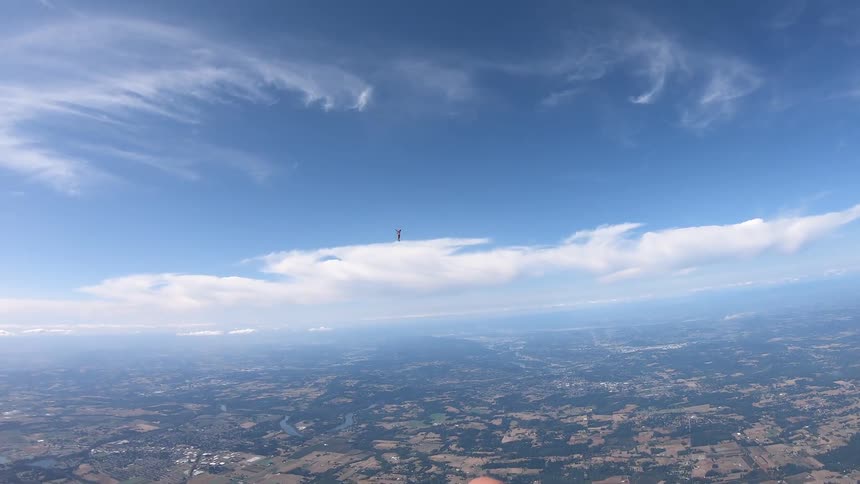 Man parachutes above the city on a sunny day