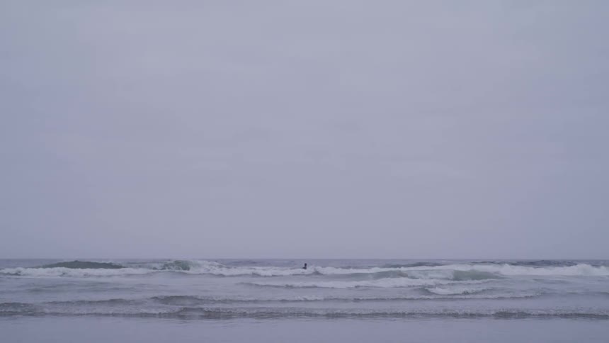 A man surfing in the middle of the ocean waves
