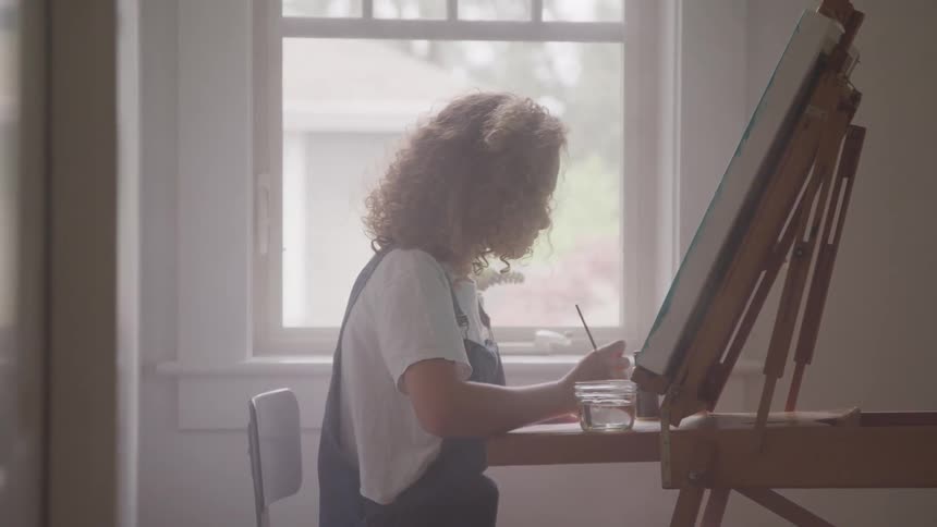 A painter painting at the canvas