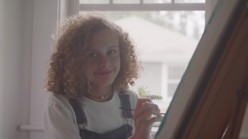 A curly woman painting