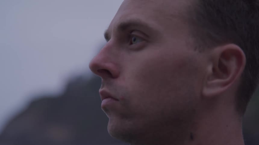 Man looks ahead outdoors on a cloudy day