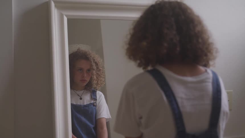 Curly girl in front of the mirror