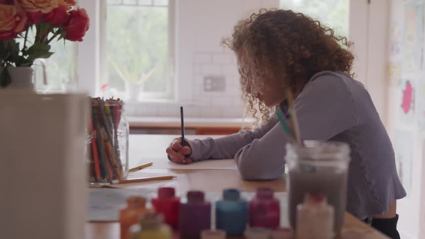 A curly female writing at the room