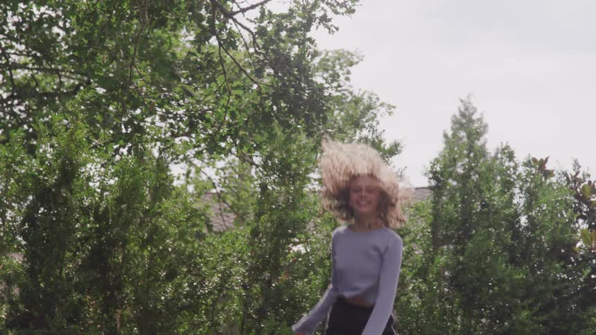 A girl jumps up and down on a trampoline
