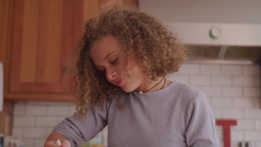 A girl stirs something with a utensil