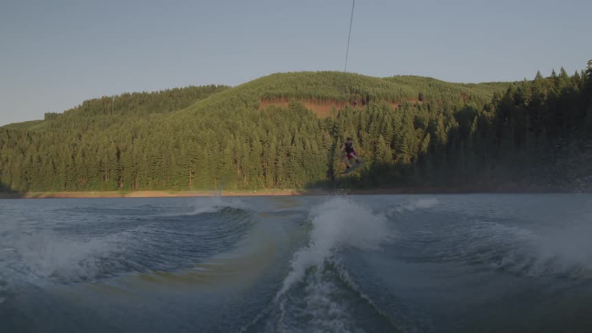 A man jumps on the water ski training from a boat