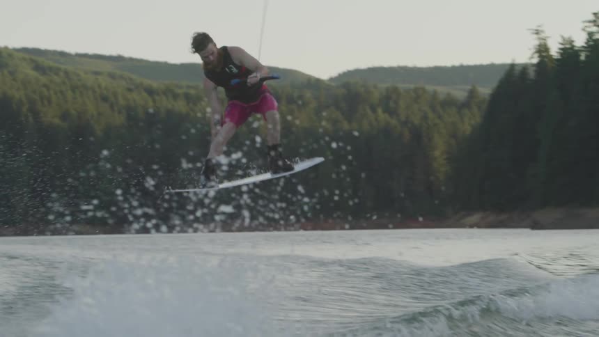 A man wake boards in a large lake