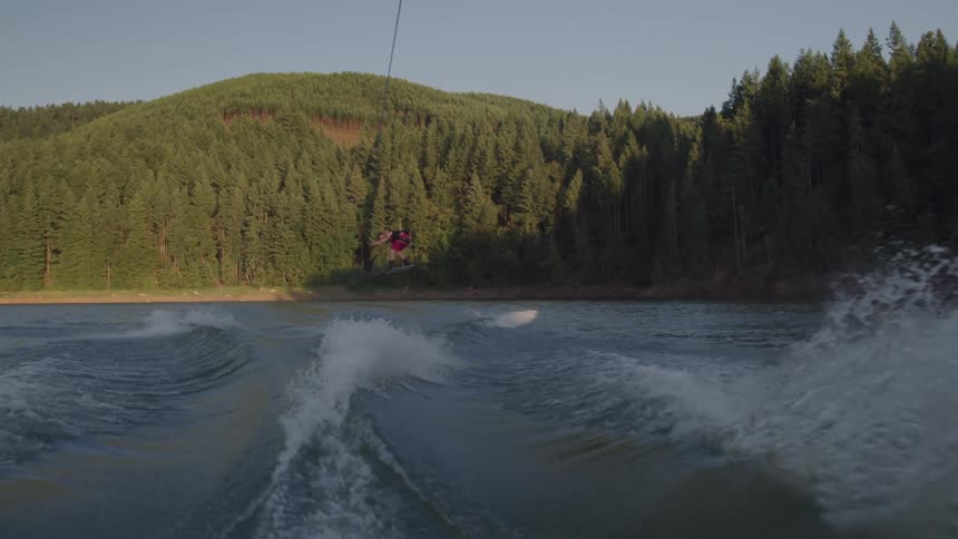 Wakeboarder jumping over a wake on the lake