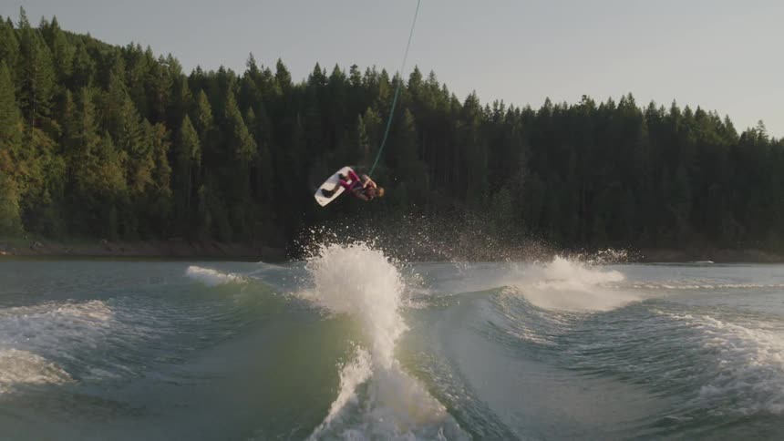 Man practicing water sky jumps over waves in lake