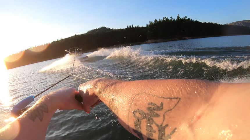 A man water skis behind a boat