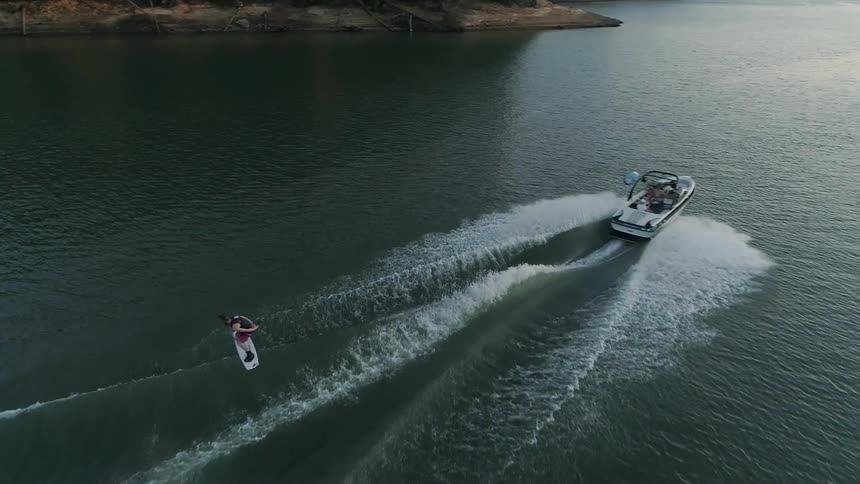 A young man does jumps while water skiing