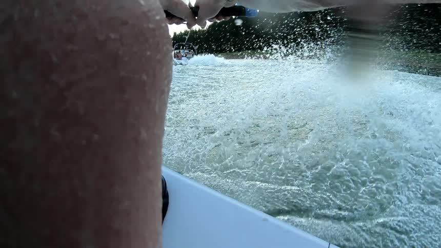 A man has his hands wrapped around a handle while water skiing