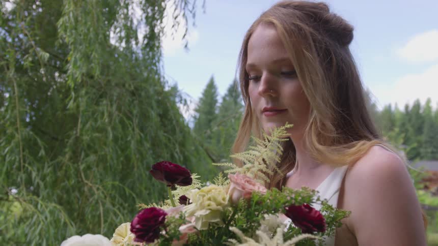 A woman stares at her bouquet