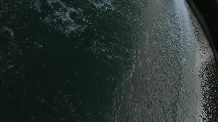 A person water skiing does a flip in the air over a wave