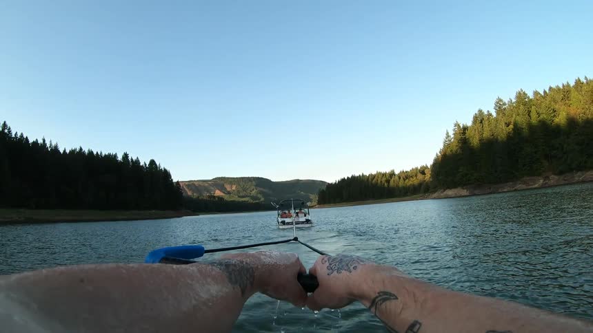 Man practices water sky on lake at sunset