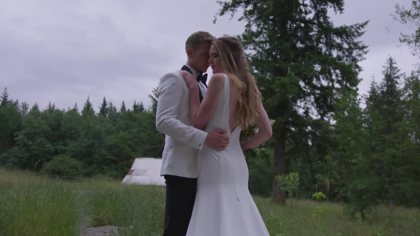A bride and groom dance in the grass
