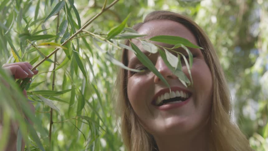 Beautiful young woman playing with leaves