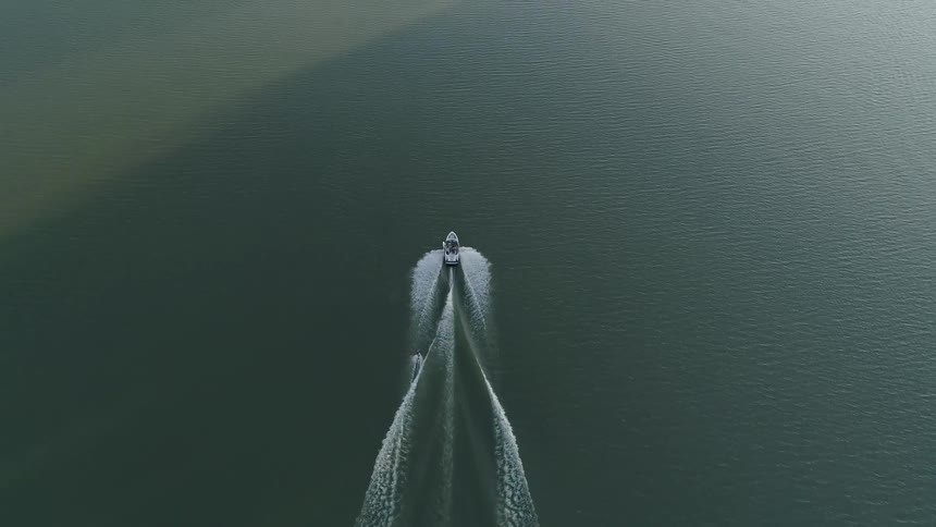 A boat pulls a water skier thought a lake
